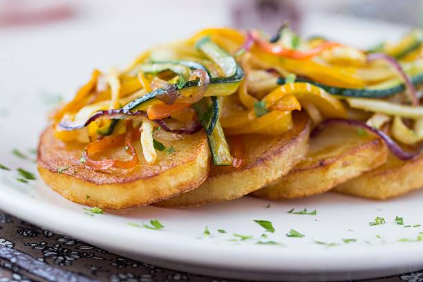 Fried slices of potato with finely chopped sticks vegetables stock photo