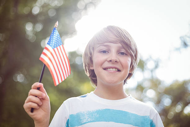 istock Young boy holding an american flag 481729092