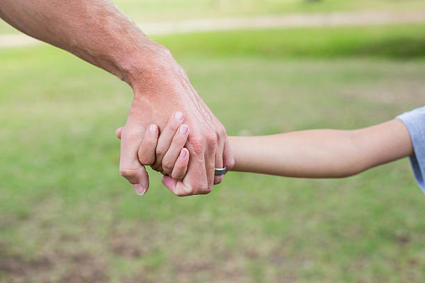 istock Father and son holding hands in the park 481730380