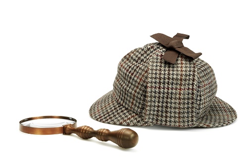 Sherlock Holmes Deerstalker Cap And Vintage Magnifying Glass Isolated On White Background. Investigation Concept