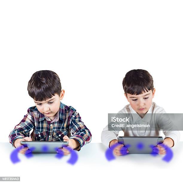 Niños Jugando Con Una Tableta Digital Foto de stock y más banco de imágenes de Adicción - Adicción, Adición al juego, Aplicación para móviles