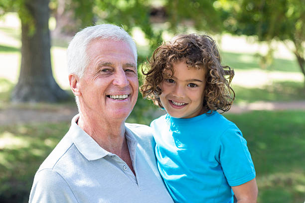 istock grandfather and grandson having fun in a park 481738314