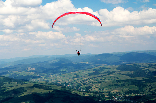 Flying paraglider and colorful countryside