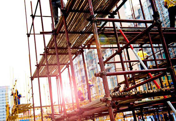 working on scaffolding Construction workers working on scaffolding construction skyscraper machine industry stock pictures, royalty-free photos & images