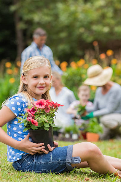 istock Young girl sitting with flower pot 481739482