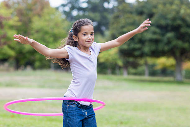 istock happy girl playing with hula hoops 481744942