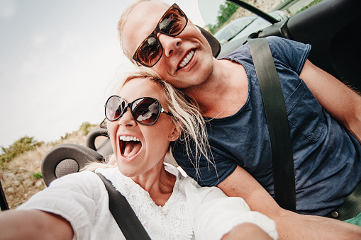 Couple on roadtrip in cabriolet car through Europe in summer