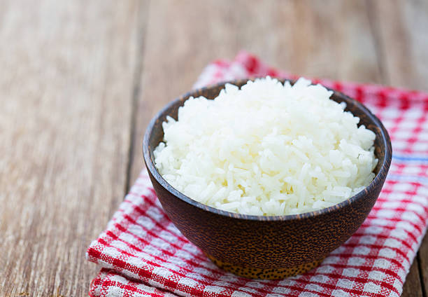 Jasmine rice in a  bowl on wood table Jasmine rice in a rice bowl on wood table jasmine rice stock pictures, royalty-free photos & images