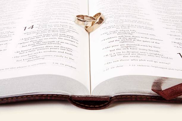 istock Two wedding rings on a bible, Corinthians Chapter 13 481751053