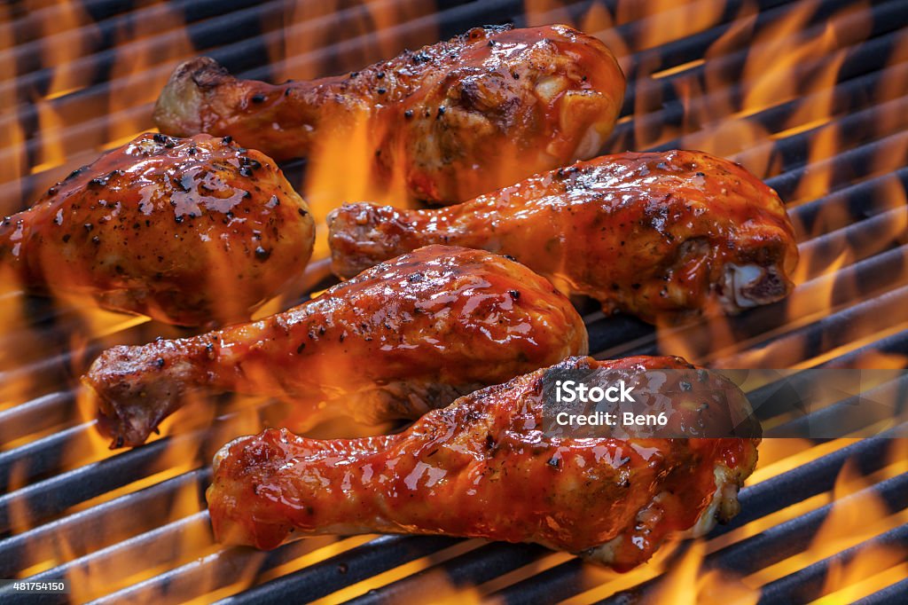 Chicken on a hot flaming Barbecue Chicken legs grilling over flames on a barbecue Barbecue Chicken Stock Photo