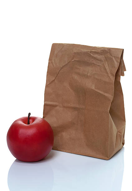 istock Brown paper lunch bag with red apple 481754560