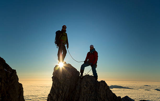 grimpeurs debout sur les rochers - mountain rock sun european alps photos et images de collection