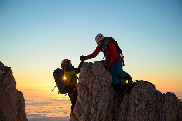 zwei männer klettern auf felsen - risk mountain climbing climbing conquering adversity stock-fotos und bilder