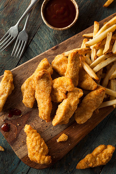 Homemade Breaded Chicken Tenders Homemade Breaded Chicken Tenders with Fries and BBQ Sauce affectionate stock pictures, royalty-free photos & images