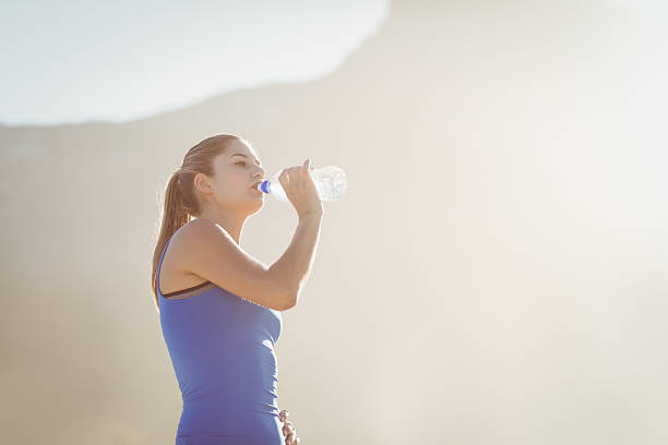 istock Beautiful fit brunette drinking water 481756094