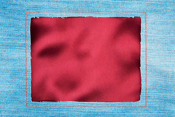 istock Frame  denim fabric with yellow stitching on red silk 481757964