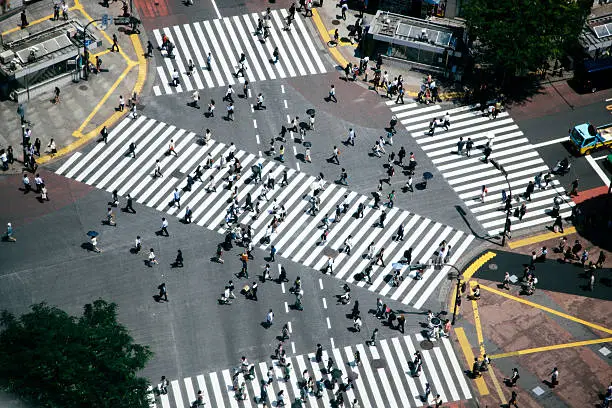 Shibuya crossing, pedestrians crossing the road, aerial view. Spring, daylight, horizontal composition. 