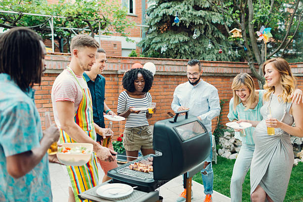 junge menschen essen im barbecue-party. - gartenparty stock-fotos und bilder