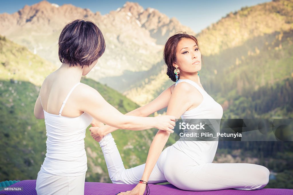 Asian trainer conducts classes of group yoga outdoor Asian trainer conducts classes of group yoga outdoor, at mountain. Concept of a healthy lifestyle and the right attitude to life 2015 Stock Photo