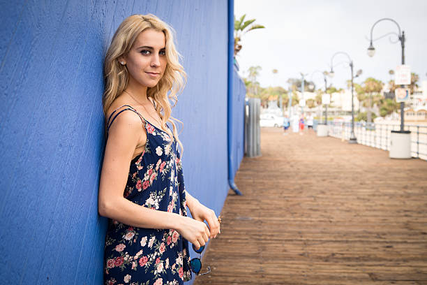 Cтоковое фото Женщина, стоя против голубой стене на пирс Санта-Моники.