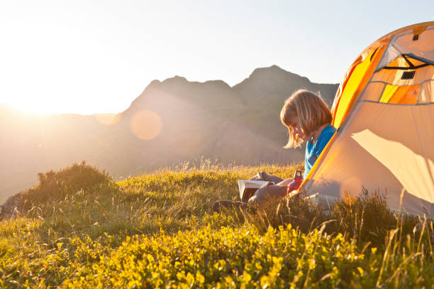 istock Child reading in idyllic summer sunset light camping in mountains 481774225