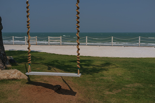 A woman contemplates the sea from a swing on the shore of the Caribbean Sea in Sian Kaan, in the Mayan Riviera