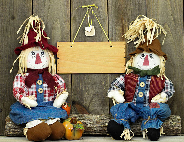 l'épouvantail assis sur un panneau de bois vierge - child autumn scarecrow decoration photos et images de collection