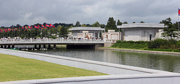 North Korea DPRK: Kumsusan Memorial Palace Of The Sun Pyongyang, North Korea - August 14, 2013: Locals flock over the entrance/bridge to the Kumsusan Memorial Palace Of The Sun (mausoleum of Kim Il Sung and Kim Jong Il). A palatial structure where the two leaders lay in state, and each has a museum dedicated to them. kim il sung mausoleum stock pictures, royalty-free photos & images
