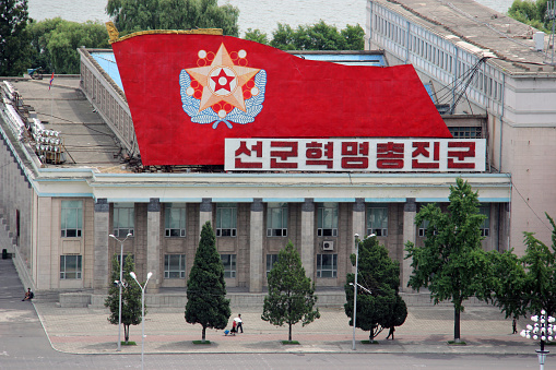 Pyongyang, North Korea - August 15, 2013: The Korean Art Gallery is situated on Kim Il Sung Square. Built in 1954, it houses many of the treasures of the DPRK's collection. Atop the building is a flag with the hammer, sickle, and brush emblem that permeates North Korea's iconography.