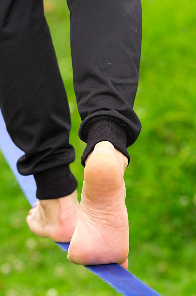 istock Closeup man feet walking on slackline and grassy background from 481793846