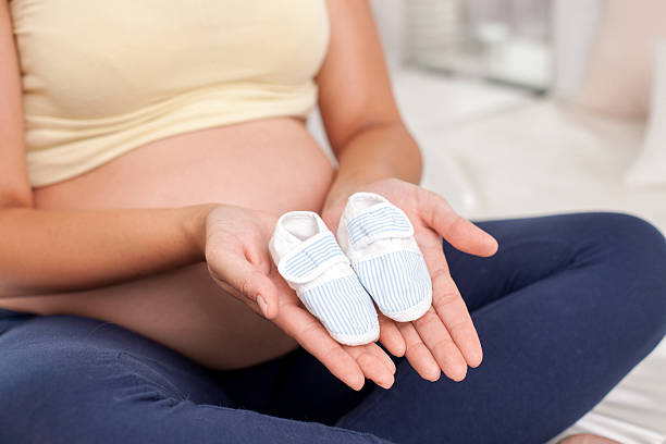 istock Young expectant mother is playing with baby booties 481794204