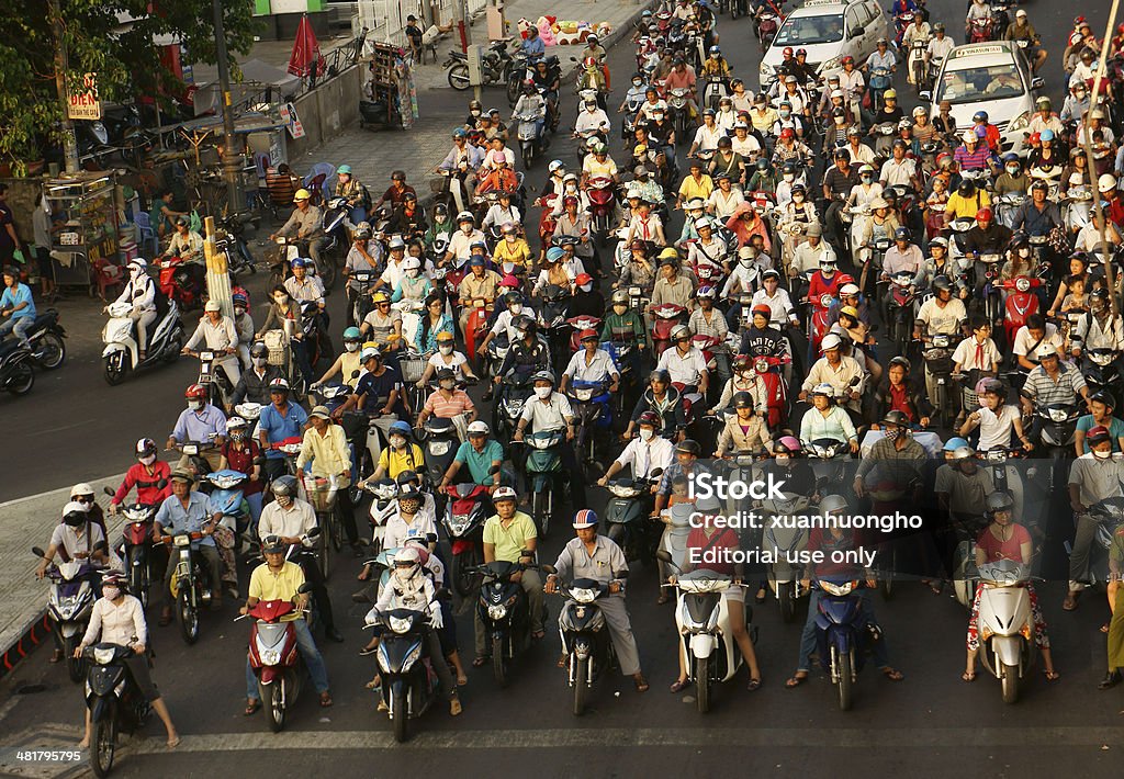 crowed  scene of urban traffic  in Vietnam rush hour Ho chi minh city, Viet Nam - March 27, 2014: Amazing, crowed  scene of urban traffic  in rush hour, crowd of people wear helmet, ride motorbike, stop at red light in waiting situation, Vietnam, Mar 27, 2014 Large Group Of People Stock Photo