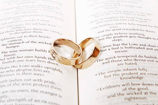 istock Two wedding rings on a bible, Corinthians Chapter 13 481797023