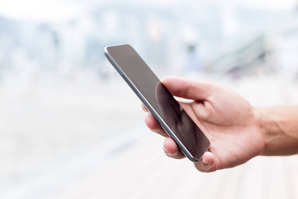 istock hand holding mobile phone on street 481806560