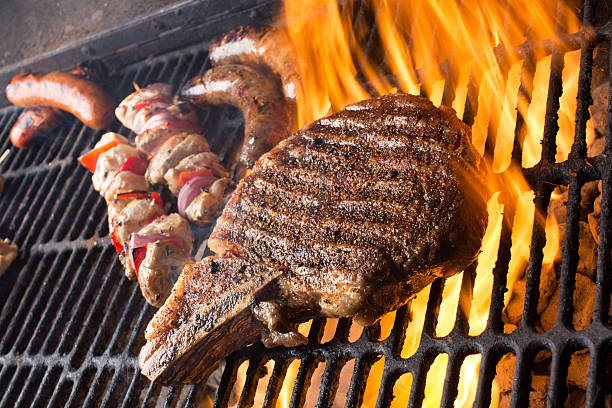 istock Huge Rib Eye Steak with Shish Kebabs, Brats on Grill 481814466