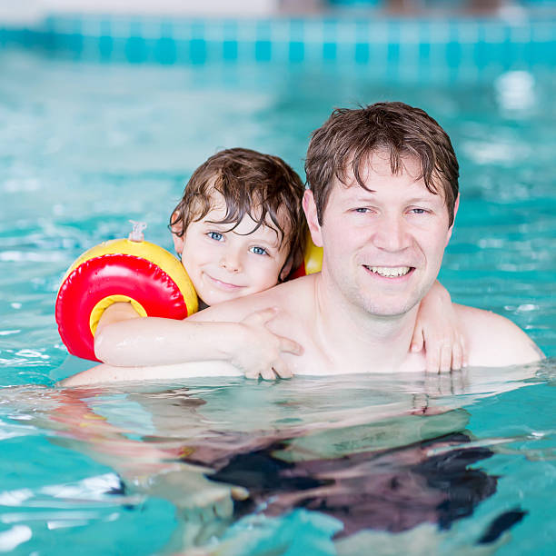 istock Young dad teaching his little son to swim indoors 481817540