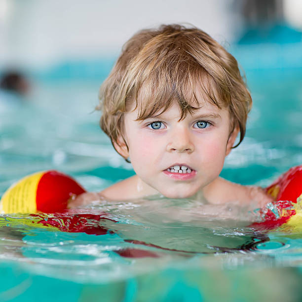 istock little kid boy swimming in an indoor pool 481817544