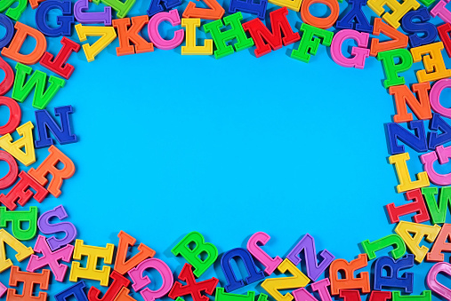 Frame of plastic colorful alphabet letters on a blue background