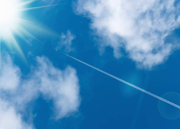 istock Airliner with vapour trail heading for the sun 481826086