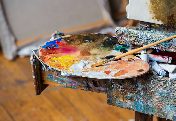 istock Paintbrush with white oil paint on a classical palette 481826092