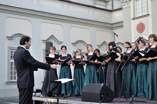 Warsaw, Poland - June 28, 2009: Warsaw University of Technology Academic Choir sing during the concert in the court of the Royal Castle. Dariusz Zimnicki conducts the choir.