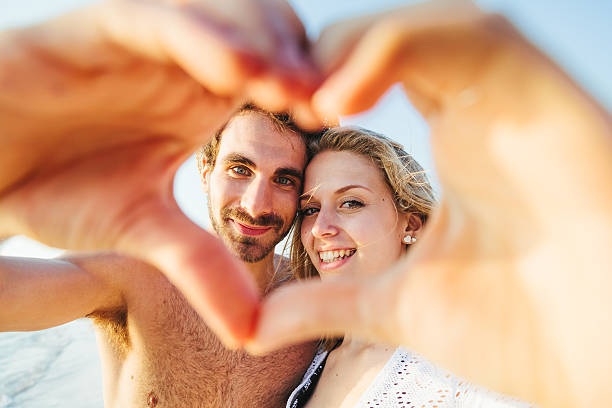 istock Loving couple on the beach seen through heart made 481831984