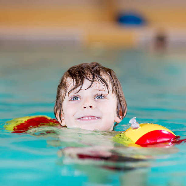 istock little kid boy with swimmies learning to swim 481836194