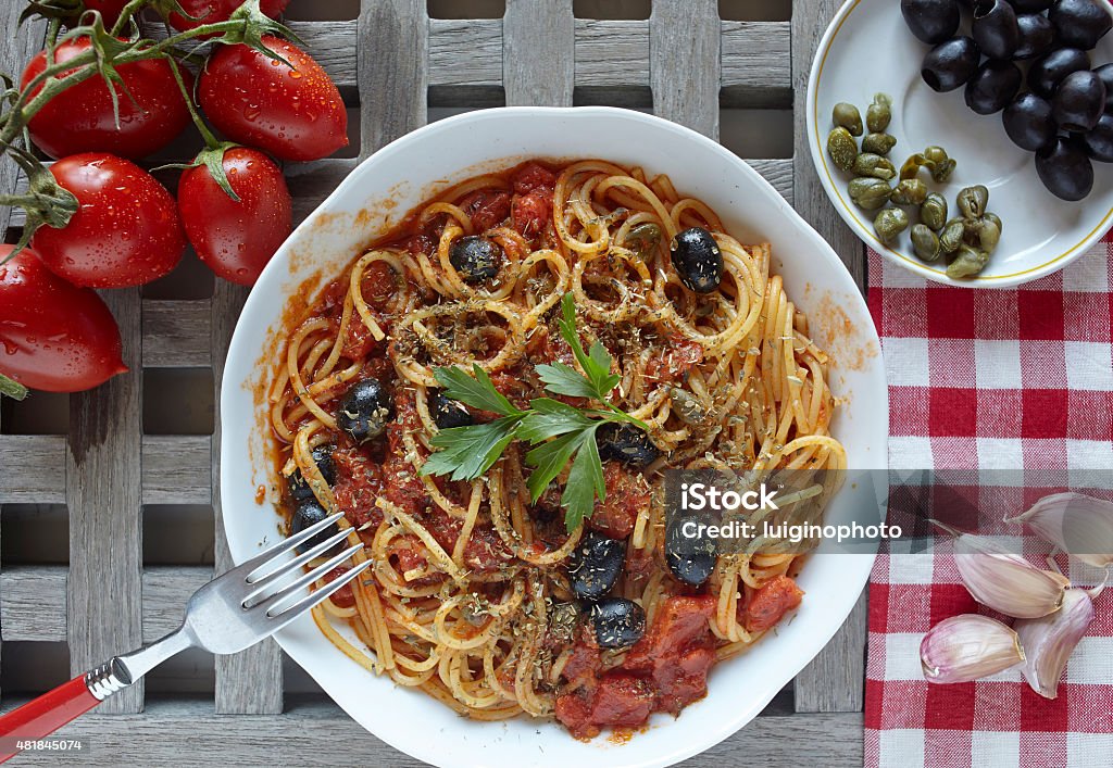 italian food: pasta alla puttanesca with tomatoes, olives,capers italian food: pasta with tomatoes, olives and capers, called puttanesca Puttanesca Stock Photo