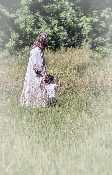 jesus christus gehen hände halten mit kleinen jungen - serene people tranquil scene child god stock-fotos und bilder