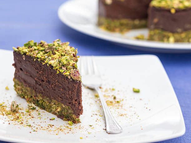 Piece of delicious raw vegan pistachio chocolate cake stock photo