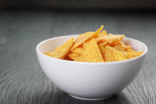 istock tortilla chips in white bowl with tomato sauce on table 481850416