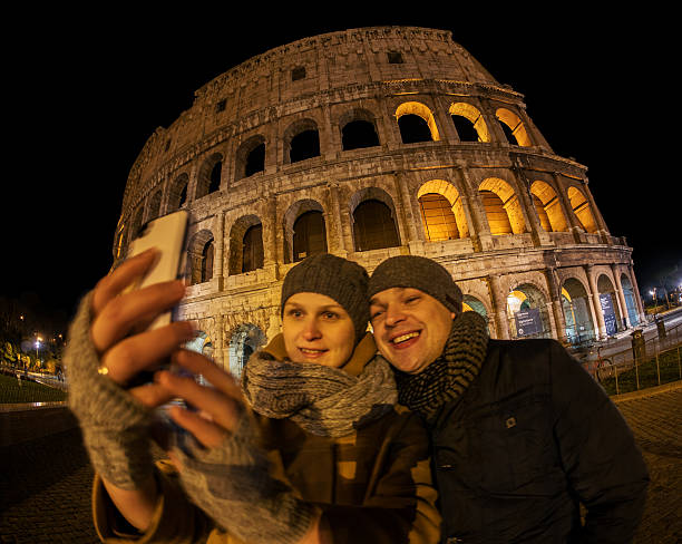 istock Happy couple making selfie by Coliseum at night 481851352