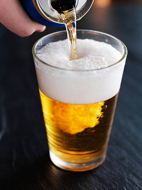 istock filling up a glass with beer from can 481851408