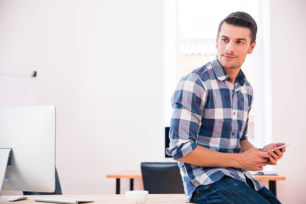 istock Handsome businessman holding smartphone and looking away 481853152